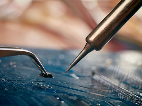 montagem de placas eletrônicas sendo feita com ferro de solda.