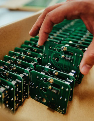 Placas eletrônicas sendo embaladas em caixa de papelão.